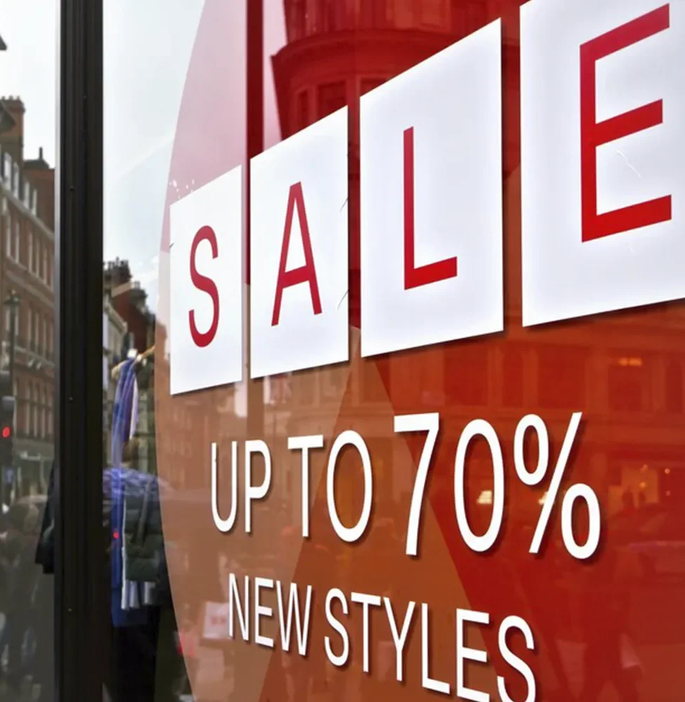 Cartel de tienda que anuncia una venta con hasta 70% de descuento en nuevos estilos.