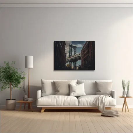 Sala de estar moderna con sofá, lámpara, planta y una fotografía de un puente urbano.