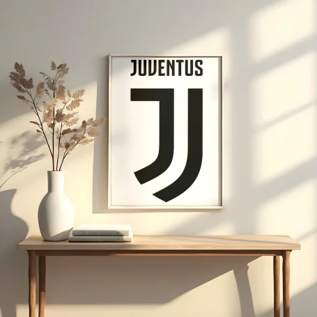 Logotipo de la Juventus en un marco sobre una mesa junto a una planta decorativa.