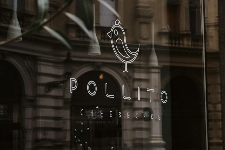 Logo de "Pollito" con un dibujo de un pollito en un fondo arquitectónico.