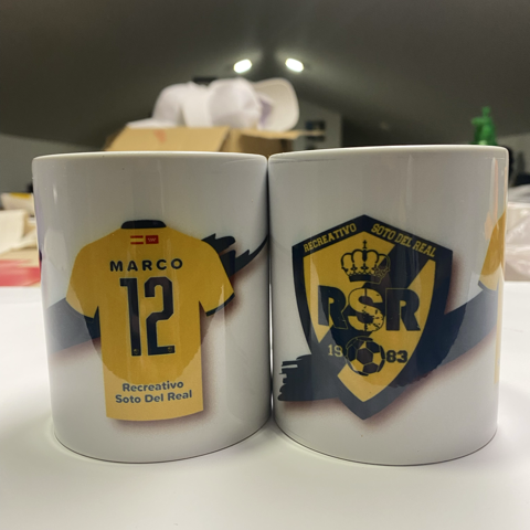 Tazas personalizadas, una amarilla con el nombre "Marco" y otra con el escudo del equipo.