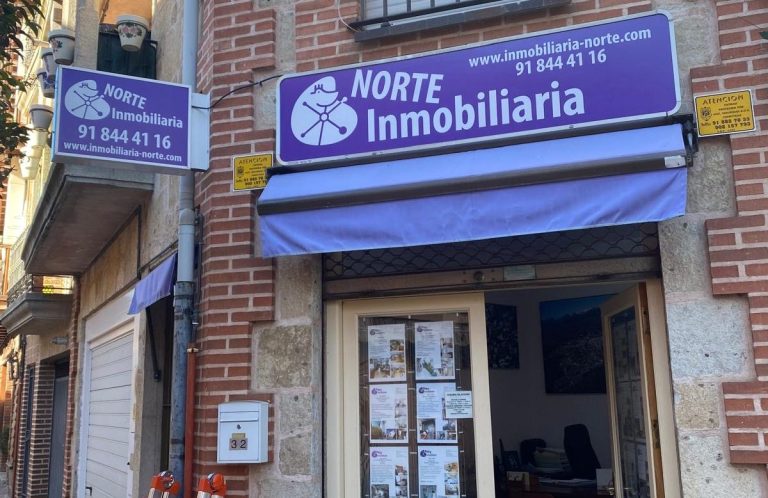 Sucursal de la inmobiliaria "Norte" con señalización y anuncios en la fachada.