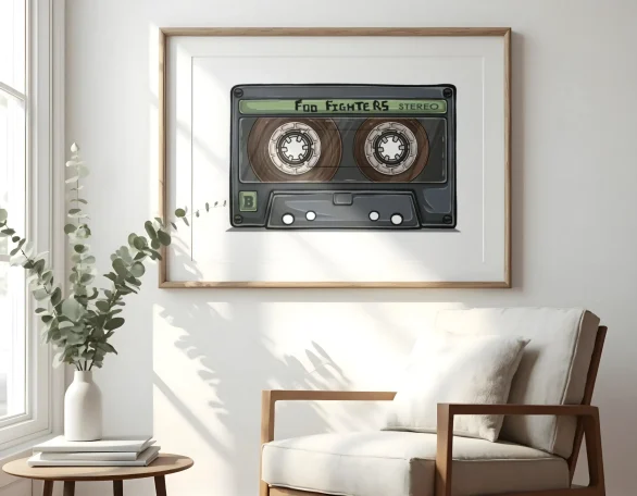 Cinta de cassette enmarcada, decorando una pared junto a un sillón y una planta.