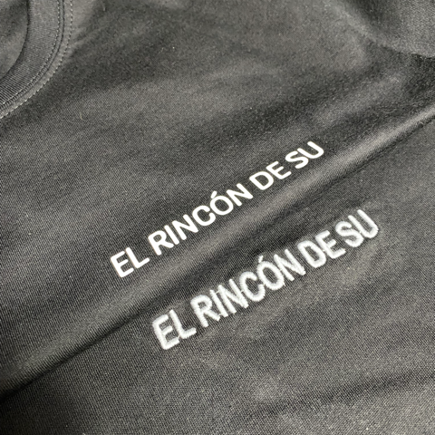Mujer sonriente en una camiseta blanca con tres perros ilustrados y una corona.
