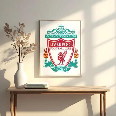 Logo del Liverpool FC en un marco, con flores secas al lado sobre una mesa.